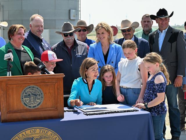 Iowa Gov. Kim Reynolds, center, visited the Pat Blomme farm near Ladora to sign two bills helping the livestock industry (DTN/Progressive Farmer photo by Jennifer Carrico)