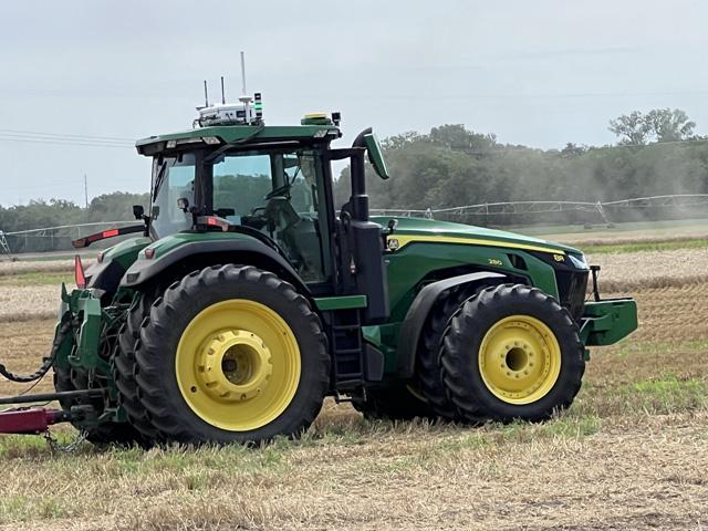 Initially, AGCO is mounting its autonomous grain cart retrofit to one of its Fendt tractor models and to Deere's 8R tractor. See here the white-colored retrofit mounted to the top of a Deere 8R tractor. Autonomous retrofits for additional tractor brands will be soon coming. (DTN photo by Dan Miller)