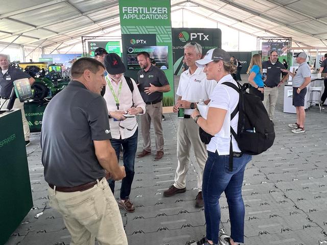 Eric Hansotia, chairman, president and CEO of AGCO, (center, white shirt) talks at the Farm Progress Show in Iowa about the downturn in the farm machinery industry and about AGCO's application of innovation and technology to help weather the financial storm. (DTN photo by Dan Miller)