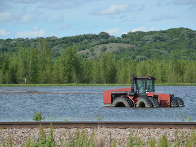 A tractor caught in the flood of 2019 on the Missouri River in Iowa. A bipartisan group of U.S. senators on Thursday wrote Agriculture Secretary Brooke Rollins calling on her to reverse a USDA decision that ends the option for farmers to buy higher coverage levels for prevented-planting policies. (DTN file photo by Chris Clayton)
